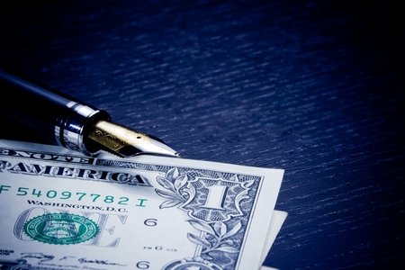 detail of dollars near golden fountain pen on old woodの写真素材