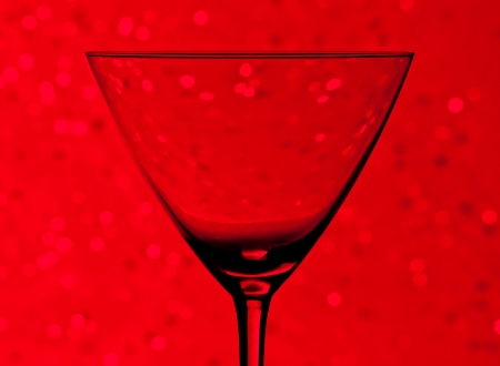 silhouette of empty cocktail glass  on red light tint bokeh backgroundの写真素材