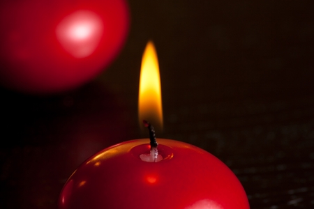 detail of a red christmas candle on wood table background with space for textの写真素材