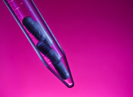blue pills in test tube, health care concept on violet background with space for textの写真素材