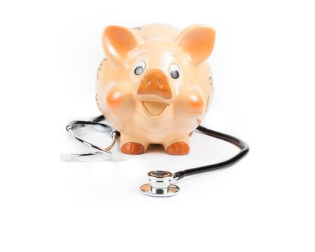 stethoscope in front of piggy bank a piggy bank on white background with space for text, concept for save moneyの写真素材