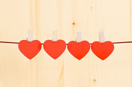 red hearts hanging on wood background with space for textの写真素材