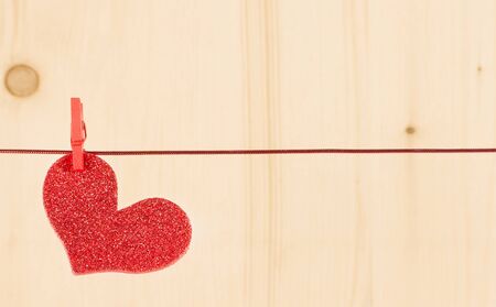one decorative red hearts hanging on wood background with space for text.の写真素材