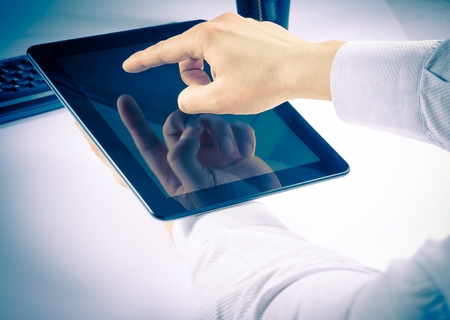 businessman holding digital tablet pc in the office on white 