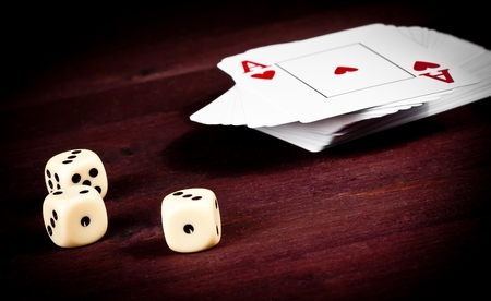 dice near playing card on old wood table, concept of poker game texas の写真素材