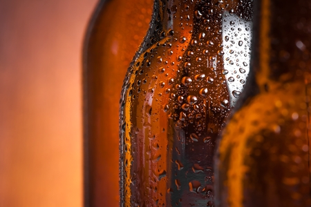 detail of bottle of fresh beer with drops, with space for text on wood backgroundの写真素材