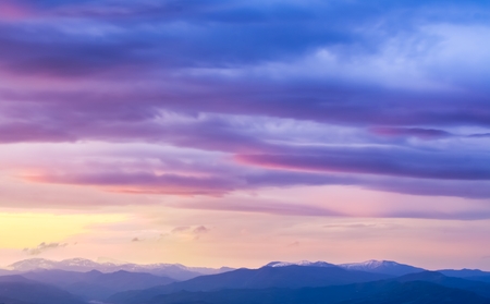 sunset on the mountains landscape with snow on topの写真素材