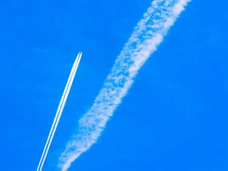 contrails of aircraft against a blue sky, routes in airwaysの写真素材