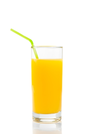 full glass of orange juice with straw on white backgroundの写真素材