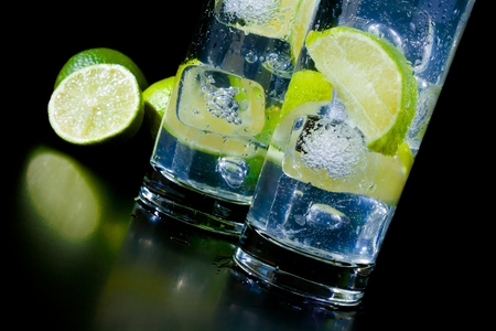 Cocktail with ice and lime slice on black table, disco club atmosphereの写真素材