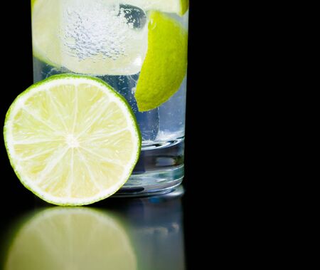 lime slice near cocktail on black background and space for textの写真素材