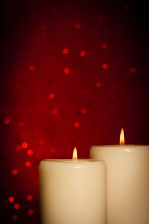 candles with flame on red bokeh background and space for textの写真素材