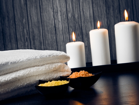 Spa massage border background with towel stacked,candles and sea salt on wood backgroundの写真素材