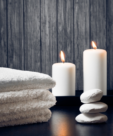 Spa massage border background with towel stacked,candles and stone on wood backgroundの写真素材
