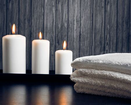 Spa massage border background with towel stacked and candles on wood backgroundの写真素材