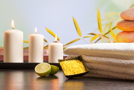 Spa massage border background with towel stacked sea salt candles and lime on natural backgroundの写真素材