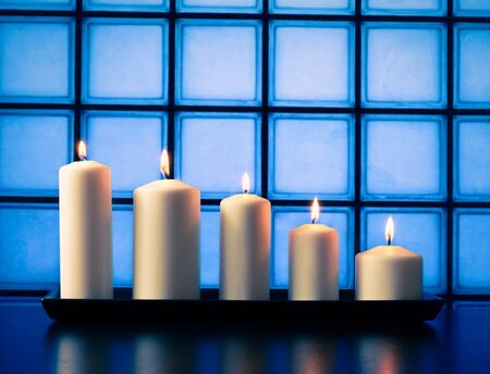 white candles on wood table on blue tiles backgroundの写真素材