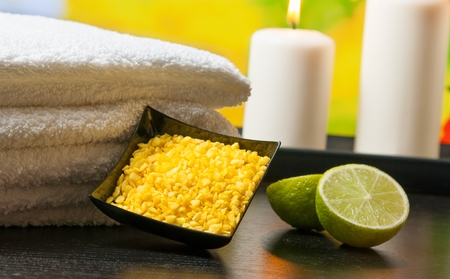 Spa massage border background with towel stacked sea salt candles and lime on green natural backgroundの写真素材