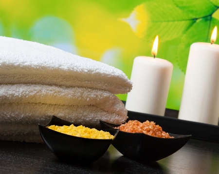 Spa massage border background with towel stacked,candles and sea salt on natural backgroundの写真素材