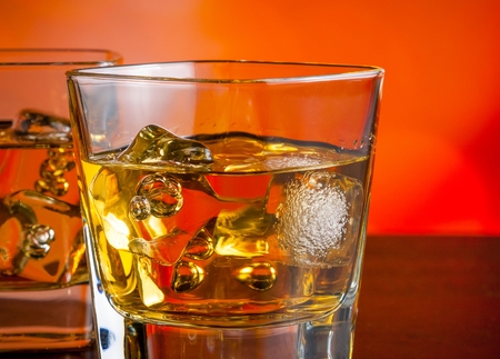 whiskey with ice on bar table on warm atmosphere lounge bar conceptの写真素材