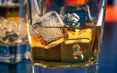 detail of whiskey with ice on bar table lounge bar atmosphereの写真素材