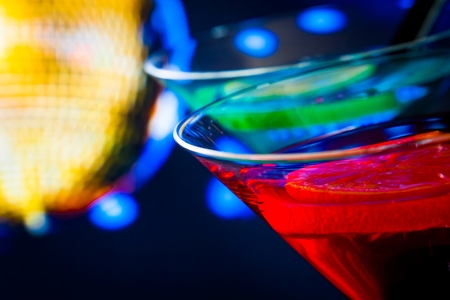 detail of red cocktail with golden sparkling disco ball background with space for text, dance disco conceptの写真素材