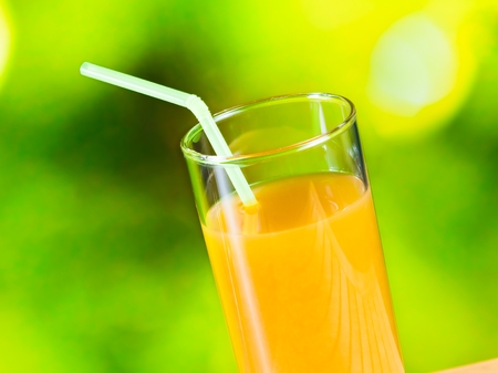 Orange juice on the wood table on green backgroundの写真素材