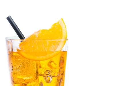 orange slice on top of the yellow cocktail with ice cubes and straw on white background, with space for textの写真素材