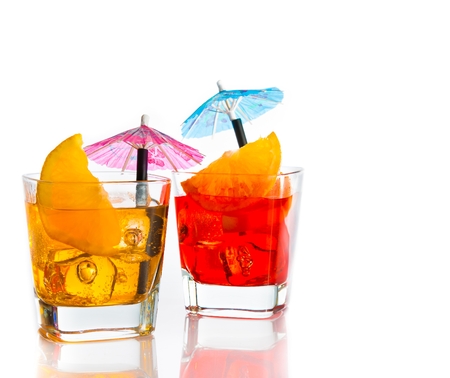 two cocktail with orange slice and umbrella on top isolated on white background with space for textの写真素材