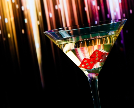 red dice in the cocktail glass on colorful gradient backgroundの写真素材