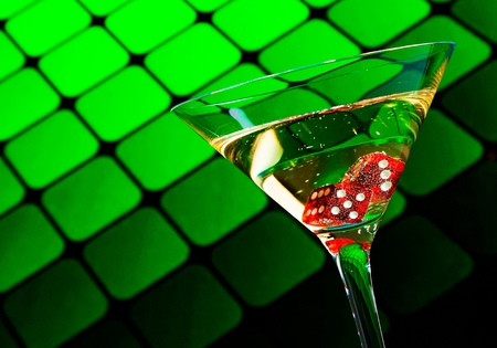 red dice in the cocktail glass on blur green backgroundの写真素材