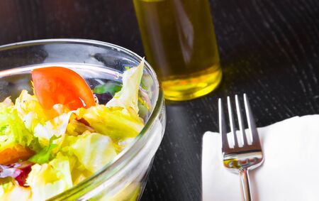 detail of fork on italian fresh salad and tomato wood restaurant table, diet conceptの写真素材