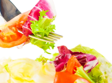 close-up of fork on italian fresh salad on white background nutrition conceptの写真素材