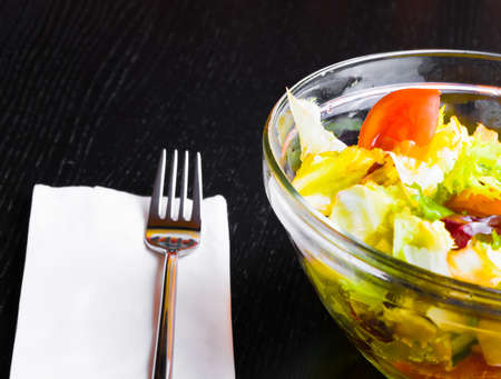 detail of fork on italian fresh salad and tomato wood restaurant table, diet conceptの写真素材