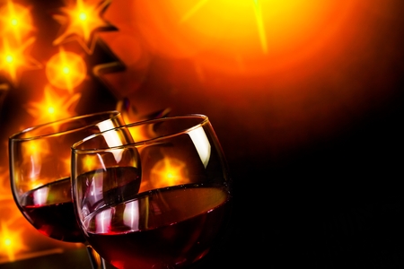 red wine glass against golden lights tree background, christmas atmosphereの写真素材