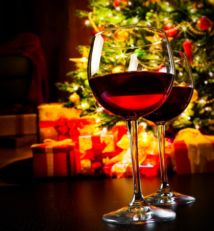 two red wine glasses against christmas tree background, christmas atmosphereの写真素材