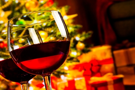 detail of two red wine glasses against christmas tree background, christmas atmosphereの写真素材