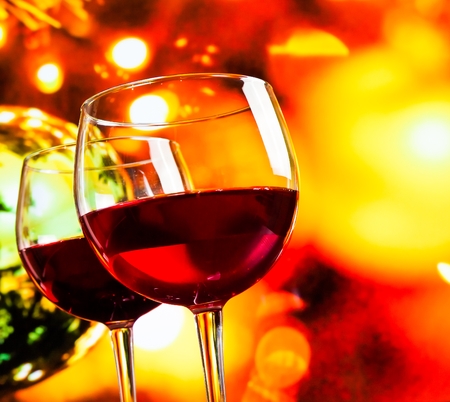 red wine glasses against colorful unfocused lights background, festive and fun conceptの写真素材