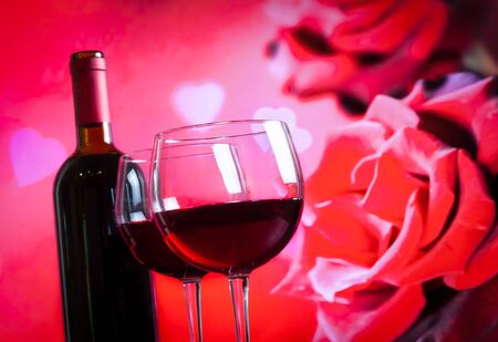 two red wine glasses on blur red roses background, festive and love conceptの写真素材