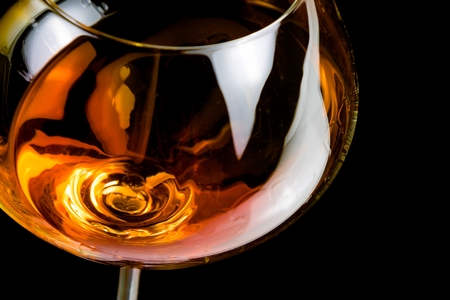 snifter of brandy in elegant glass with space for text on black backgroundの写真素材