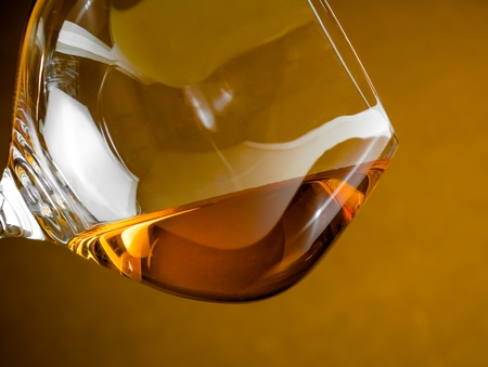snifter of brandy in elegant glass with space for text on golden backgroundの写真素材