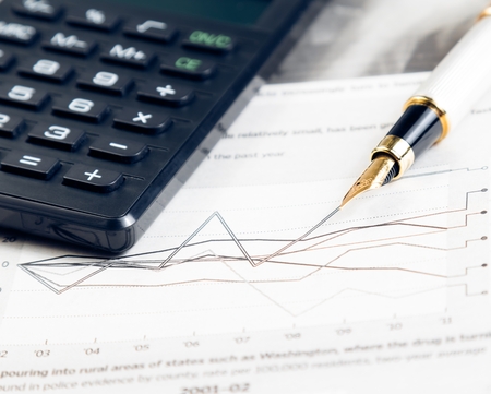 financial chart and graph near pen and calculator on financial newspaperの写真素材