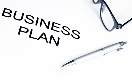 business plan words near glasses and pen on table, business conceptの写真素材