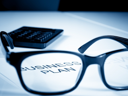 business plan words near glasses and calculator on table, business conceptの写真素材
