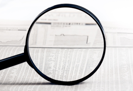 financial data and graph see through lens of loupe on financial newspaper, business conceptの写真素材