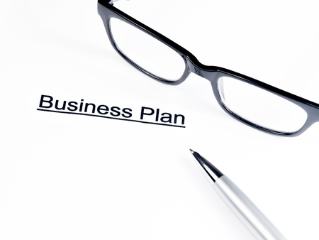 business plan words near glasses and pen on table, business conceptの写真素材