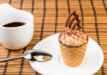delicious little coffee cake with chocolate near a cup of coffee on wood backgroundの写真素材