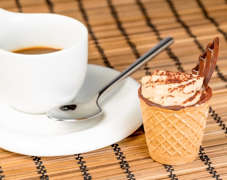 delicious little coffee cake with chocolate near a cup of coffee on wood backgroundの写真素材