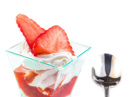 delicious strawberry cake with cream on white near a spoonの写真素材