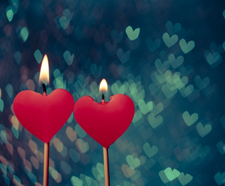 red hearts candles on vintage hearts bokeh as background, valentine day and love conceptの写真素材